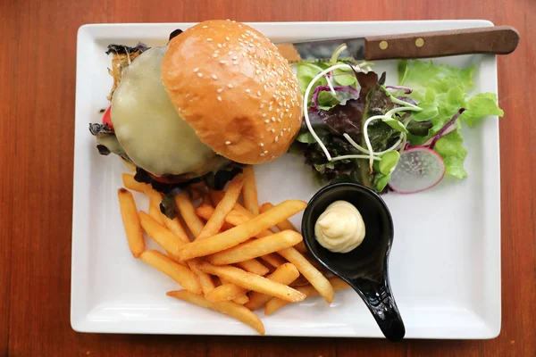 Hamburger de boeuf avec frites et salade sur fond bois — Photo