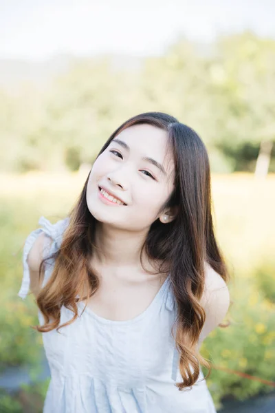 Portret van jonge Aziatische vrouw meisje glimlach in bloementuin — Stockfoto