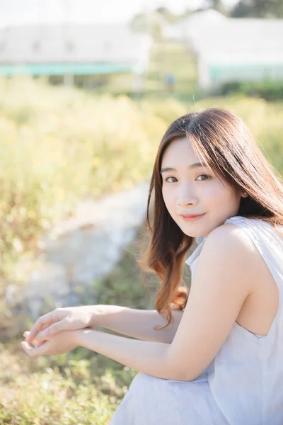 Retrato de jovem mulher asiática menina sentado e sorriso em flor g — Fotografia de Stock