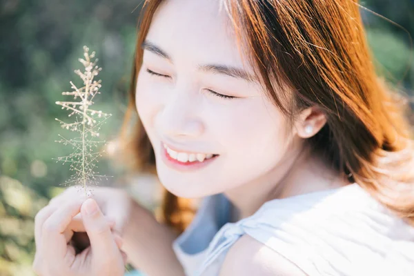 Ritratto di giovane ragazza asiatica sorridere nel giardino fiorito — Foto Stock