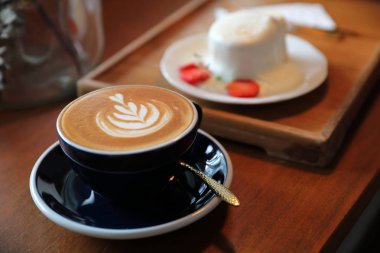 Ahşap zemin üzerinde kapuçino kahve molası