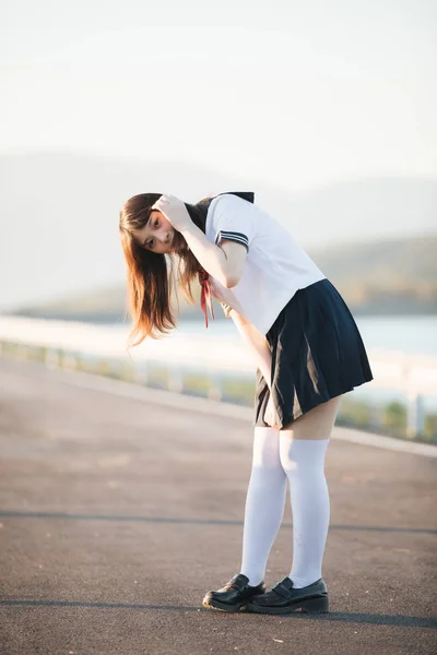 Portret van Japanse schoolmeisje uniform glimlach met loopbrug en — Stockfoto