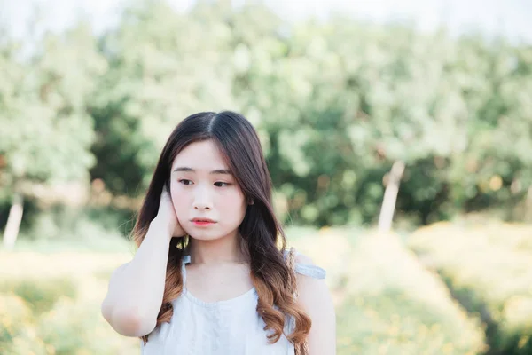 Ritratto di giovane ragazza asiatica sorridere nel giardino fiorito — Foto Stock