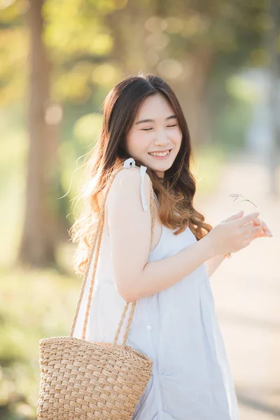 Portret młodej azjatyckiej dziewczyny uśmiech w ogrodzie kwiatowym — Zdjęcie stockowe