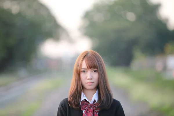 Retrato de ásia japonês escola menina traje olhando para o parque o — Fotografia de Stock