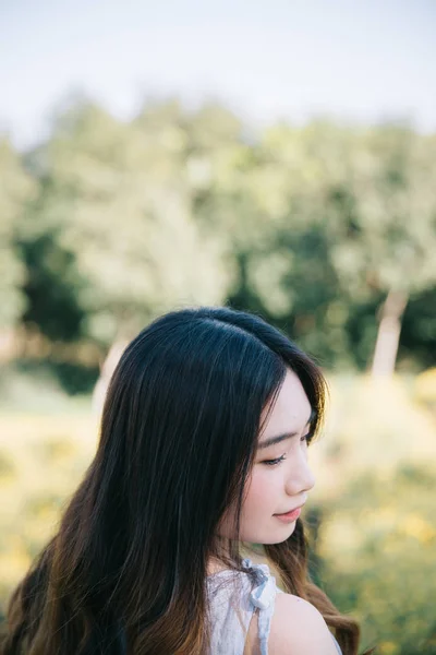 Portret van jonge Aziatische vrouw meisje glimlach in bloementuin — Stockfoto