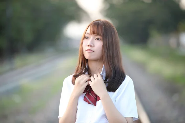 Retrato de asiático japonés escuela chica traje buscando en parque o —  Fotos de Stock