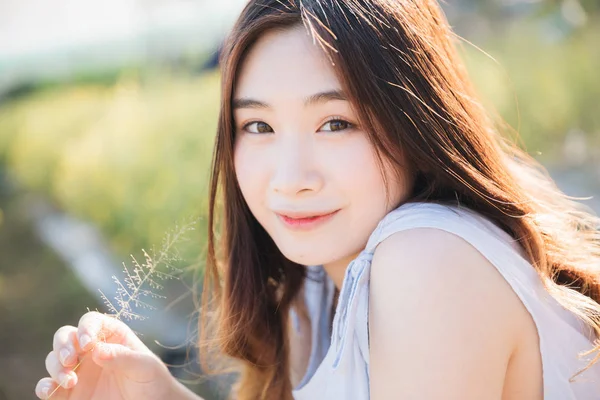 Retrato de joven mujer asiática sentada y sonrisa en flor g —  Fotos de Stock