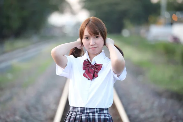 Ritratto di asiatica giapponese scuola ragazza costume guardando parco o — Foto Stock