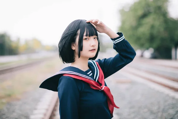 Portrait of asian japanese school girl costume looking at railwa