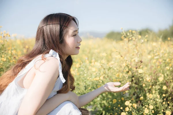 Portret van jonge Aziatische vrouw meisje zittend en glimlach in bloem g — Stockfoto
