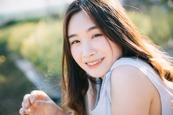 Portrait of Young Asian woman girl sitting and smile in flower g — Stock Photo, Image