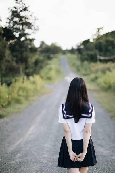 Portret azjatyckiej japońskiej szkoły dziewczyna kostium patrząc na Park — Zdjęcie stockowe