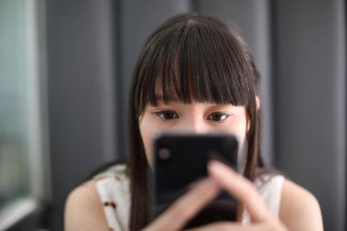 Kafe hayat tarzı iş konseptinde akıllı telefon kullanan bir kadın.