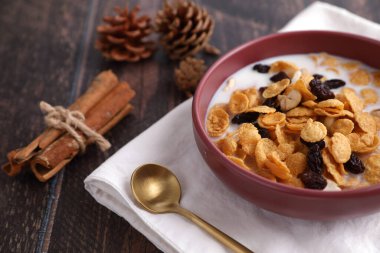 Mısır yulaflı mısır gevreği ve ahşap arka planda izole edilmiş kuru meyveler.