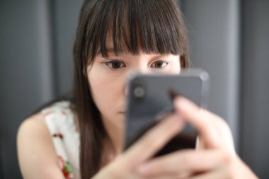 Kafe hayat tarzı iş konseptinde akıllı telefon kullanan bir kadın.