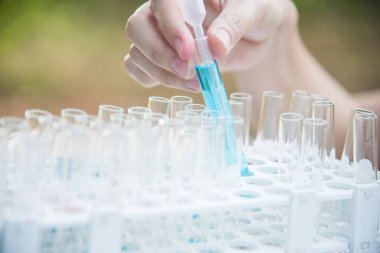 Laboratuvar bilim araştırma cam öğelerini damla birkaç test tüpleri birine ekleme. Bilimsel deneyde Bilim Araştırma Laboratuvarı.