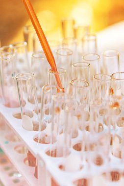 Laboratuvar bilim araştırma cam öğelerini damla birkaç test tüpleri birine ekleme. Bilimsel deneyde Bilim Araştırma Laboratuvarı.