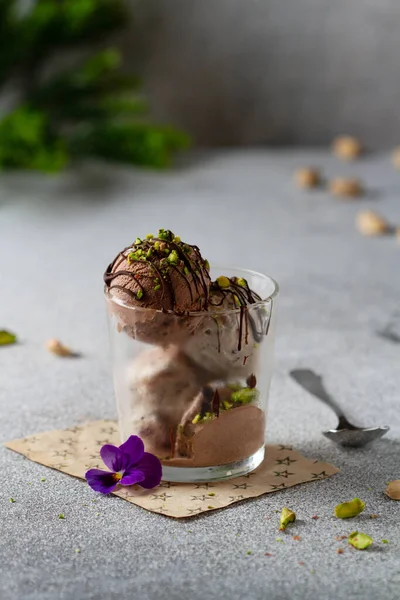 Шарики Шоколадного Мороженого Стеклянной Чашке Посыпанные Дроблеными Фисташками Украшенными Фиалками — стоковое фото