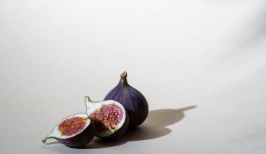 Bej arka planda mor incir meyveleri, parlak gölge, kesim, posa