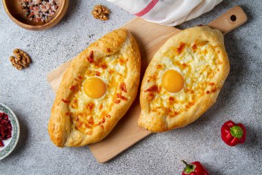 Açık gri arka planda peynirli ve yumurtalı Gürcü tekneleri, üst manzara, ulusal yemek