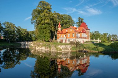 Eski ahşap ev ve Kuressaare, Estonya, eski kale çevresindeki hendek onun yansıması akşam güneş tarafından aydınlatılmış