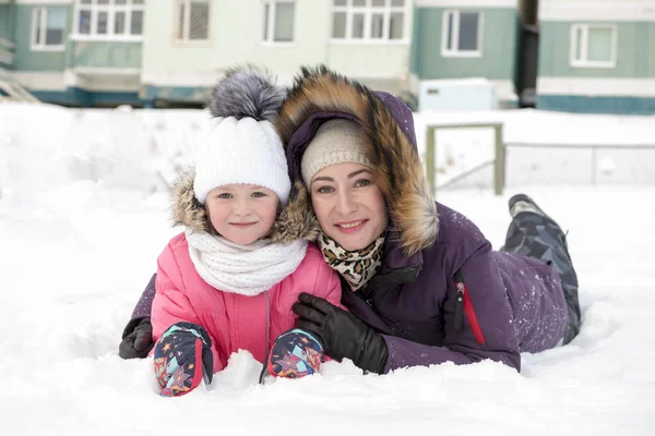 Madre Hija Tumbadas Suelo Nevado Mirando Cámara —  Fotos de Stock