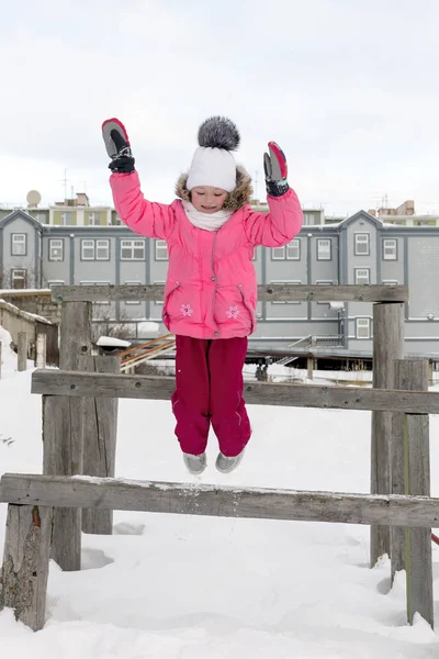 Jong Meisje Springen Van Houten Bankje Sneeuw — Stockfoto
