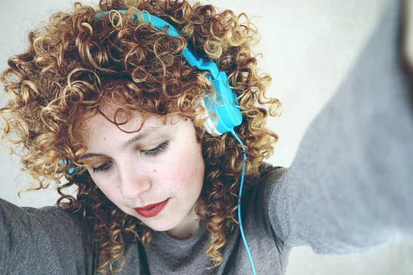 Photo Young Cute Woman Curly Hair Blue Headphones Grey Wall — Stock Photo, Image