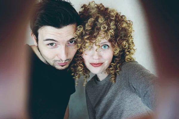 olarak adam gri duvar zemin üzerine kıvırcık saçlı Genç Sevimli kadın fotoğrafı