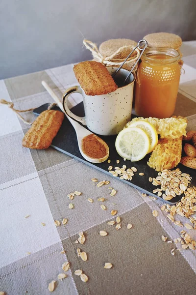 lezzet çay Kupası bal, badem fındık, taze limon ve masada tahta kaşık ile yakın çekim fotoğraf 