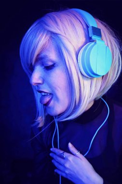Genç kadın Dj kulaklık ile mavi ve koyu ışıkların portre