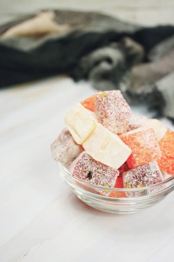 Hafif ahşap masa üzerinde Türk lokumu dolu kase               