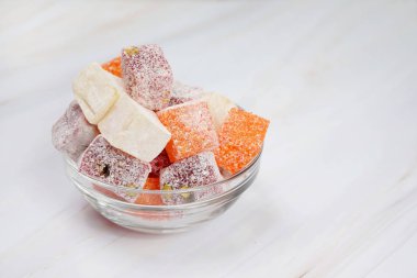 Hafif ahşap masa üzerinde Türk lokumu dolu kase               