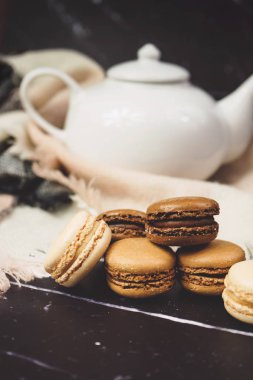 Ahşap masa üzerinde çikolata, kahve ve vanilya macaroons ve Görünümü Kapat           