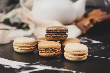 Ahşap masa üzerinde çikolata, kahve ve vanilya macaroons ve Görünümü Kapat           