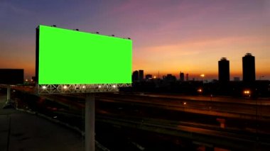 4k reklam billboard, yeşil ekran, otoyola yakın gün batımında. zaman atlamalı.