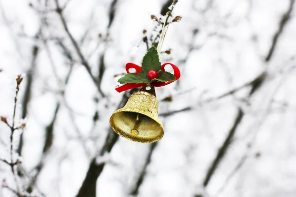 Christmas bell hanging on the tree. Gold bell hanging on a tree