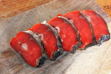 Kırmızı balık. Bir kesme tahtası üzerinde kırmızı balık dilimlenmiş.
