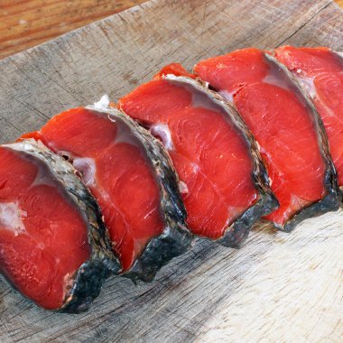 Kırmızı balık. Bir kesme tahtası üzerinde kırmızı balık dilimlenmiş.