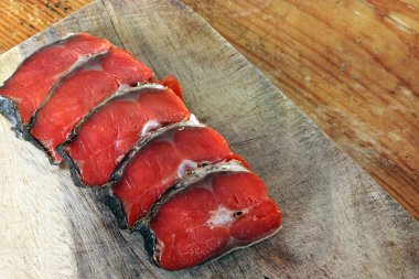Kırmızı balık. Bir kesme tahtası üzerinde kırmızı balık dilimlenmiş.