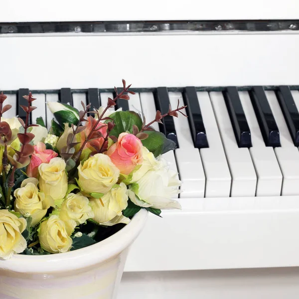 在钢琴的背景上送花玫瑰 — 图库照片