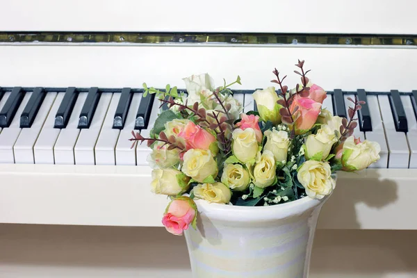 Flowers roses on the background of the piano