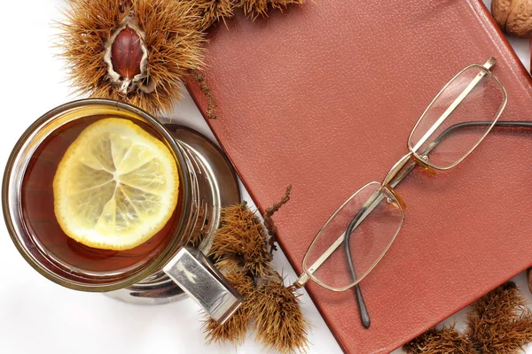 Composition. Tea, books, glasses and chestnuts