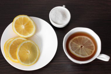 Bir fincan çay, Limonlu şeker ahşap bir masa üzerinde bir plaka üzerinde