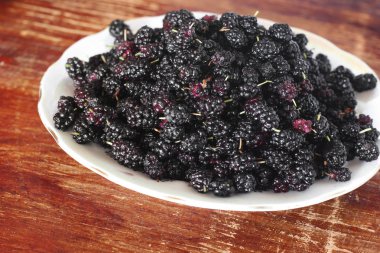 Dut. Ahşap bir masa üzerinde siyah dut