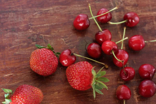 Erdbeeren Und Kirschen Auf Holzgrund — Stockfoto