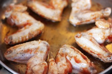 Kızarmış tavuk kanatları. Bir tavada tavuk kanadı.