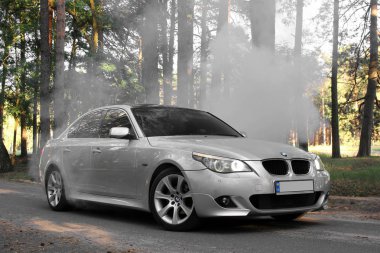 Kiev, Ukrayna - 9 Eylül 2018. BMW E60 orman yolu üzerinde. Ormanın içinde araba