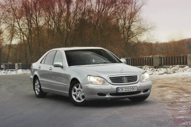 Kiev, Ukrayna - 22 Kasım 2018: Mercedes-Benz S-Class kışın ağaçlar fon karşı